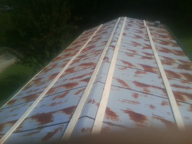 Rusted metal roof panels with new wood purlins before replacement — Storm Damage Roof Repair in Wellesley Hills by Roofing Brothers