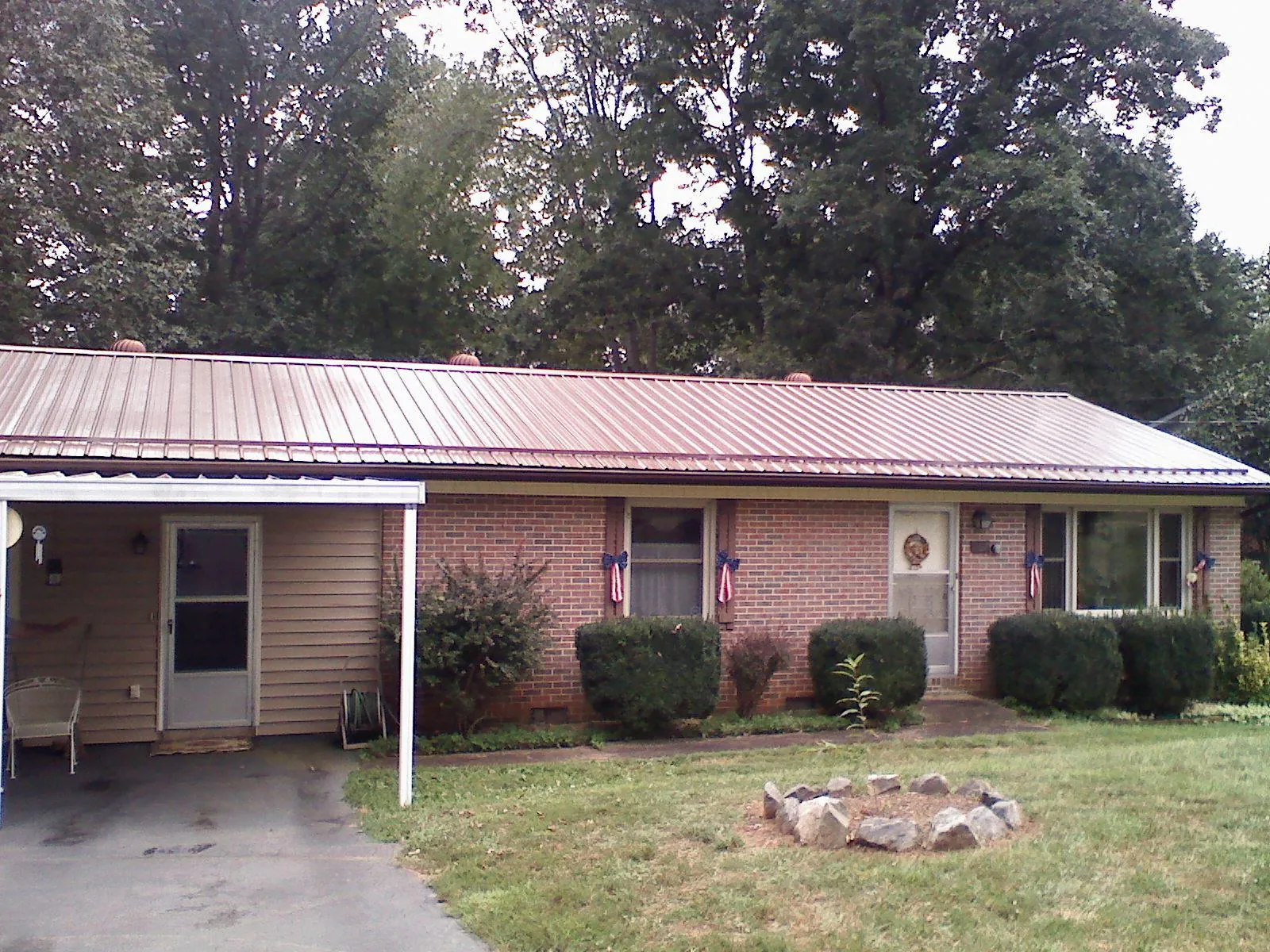 Bronze metal roof and carport on a brick ranch home — Roof Repair work by our crew in Wellesley Hills